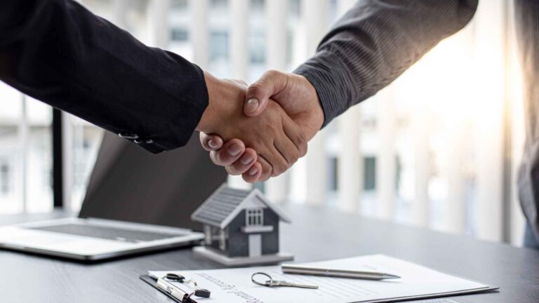 This image shows a mortgage broker in Bend, Oregon, finalizing a contract with a client, symbolizing the successful completion of a jumbo mortgage agreement.
