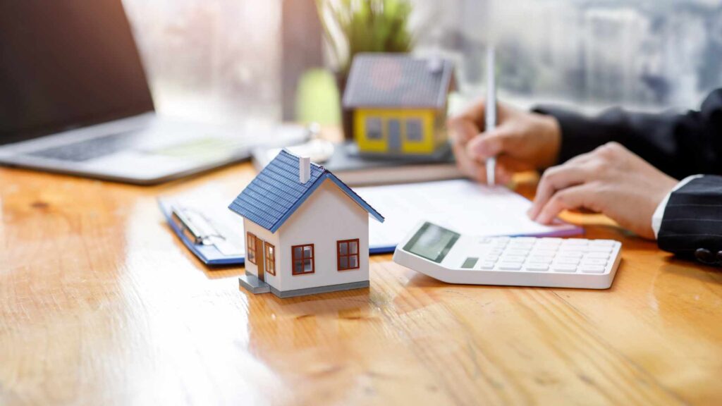 This image shows a mortgage broker in Bend, Oregon, signing a contract with a calculator beside him, symbolizing precise financial planning.