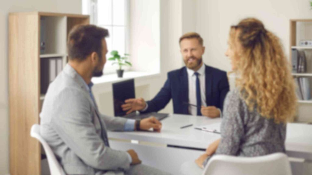 This image shows a mortgage broker in Bend, Oregon, discussing loan options with a couple.